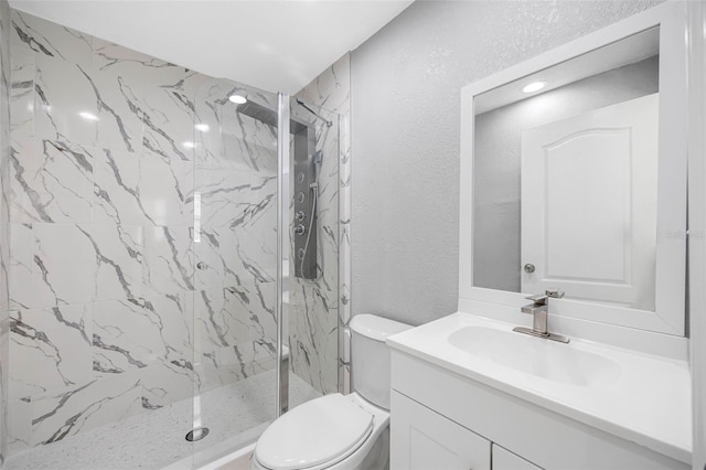 bathroom featuring a marble finish shower, toilet, vanity, and a textured wall