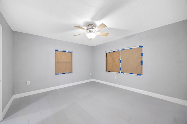 unfurnished room with baseboards and ceiling fan