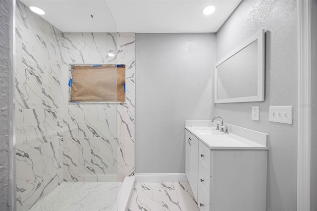 bathroom featuring marble finish floor, recessed lighting, a marble finish shower, baseboards, and vanity