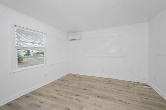 empty room featuring an AC wall unit, crown molding, wood finished floors, and baseboards