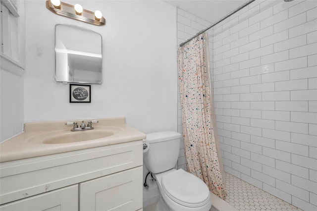 bathroom featuring toilet, vanity, and a tile shower