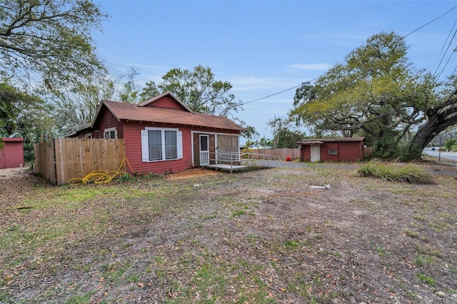 view of front of property with an outbuilding and fence