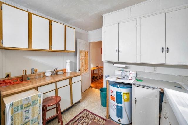 kitchen featuring water heater, white cabinetry, and light countertops