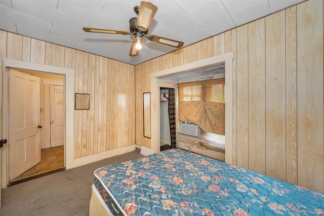 unfurnished bedroom featuring carpet flooring, a ceiling fan, cooling unit, and wood walls