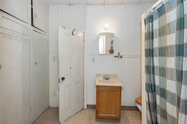 bathroom with a shower with shower curtain, toilet, tile walls, and vanity