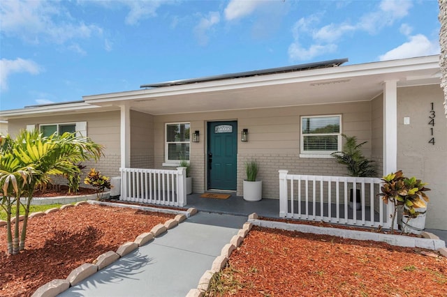 property entrance featuring brick siding and covered porch