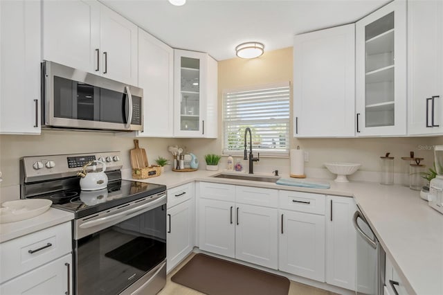 kitchen with white cabinets, appliances with stainless steel finishes, and a sink