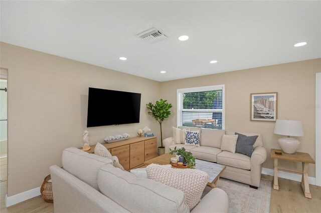 living room with recessed lighting, light wood-style floors, visible vents, and baseboards