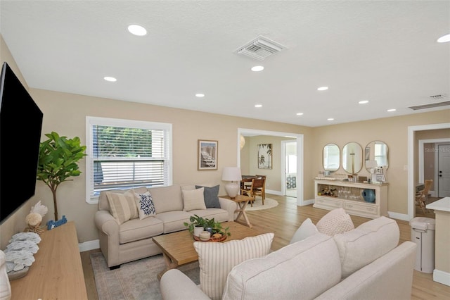 living area featuring recessed lighting, visible vents, baseboards, and light wood-style flooring