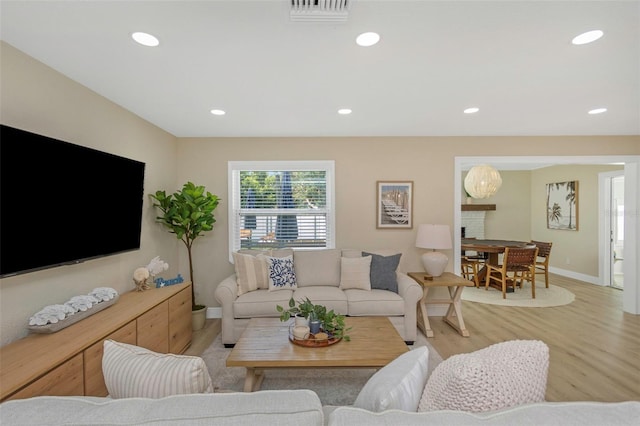 living area featuring light wood finished floors, visible vents, recessed lighting, and baseboards