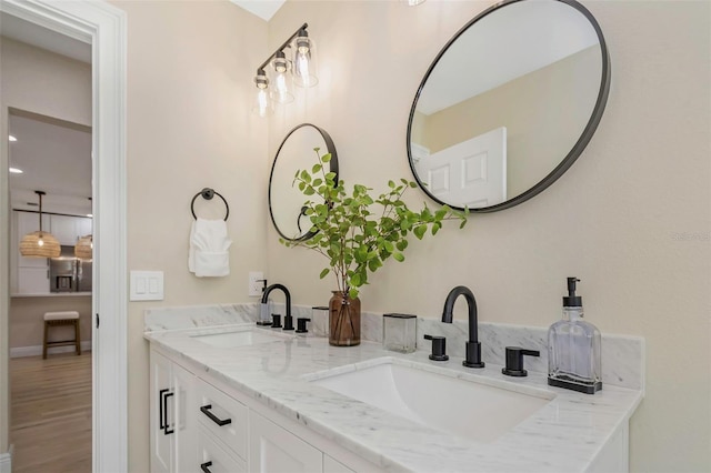 full bathroom featuring double vanity, wood finished floors, and a sink