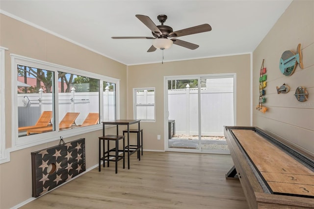 interior space with ornamental molding, baseboards, a ceiling fan, and wood finished floors