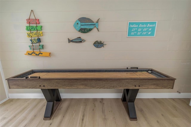 recreation room featuring baseboards and wood finished floors