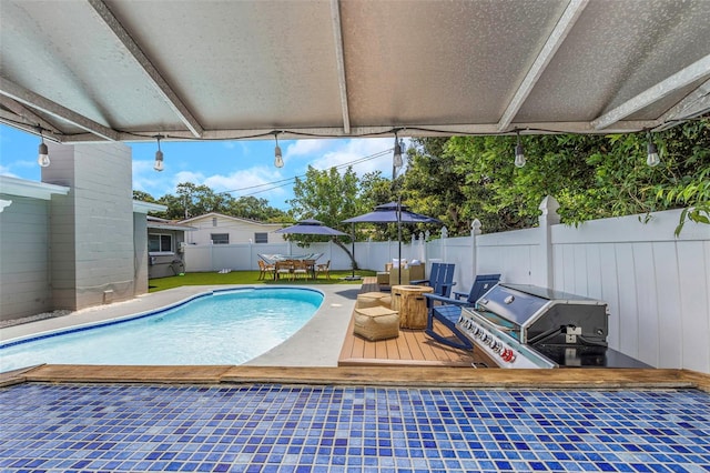 view of swimming pool with a deck, outdoor dining space, a fenced backyard, grilling area, and a fenced in pool