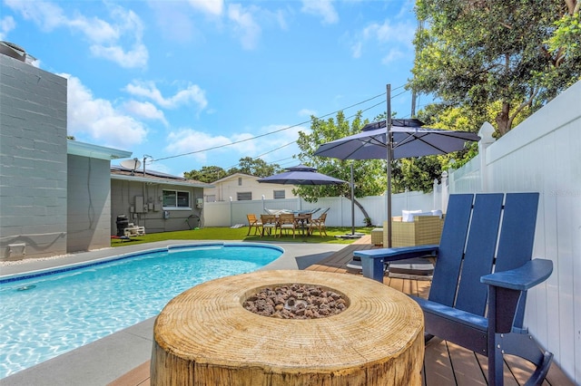 view of pool featuring outdoor dining space, a fenced in pool, a fenced backyard, and an outdoor fire pit