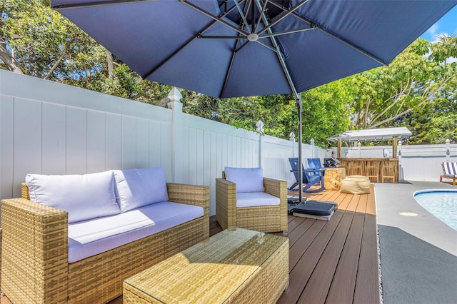 wooden terrace with an outdoor hangout area and a fenced backyard