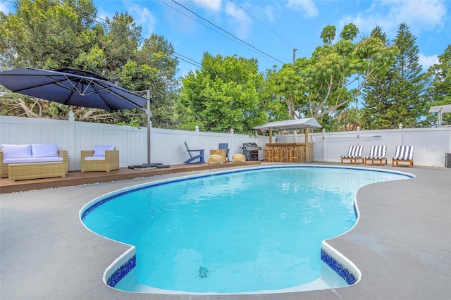 view of swimming pool featuring a fenced in pool, a patio, a wooden deck, and fence