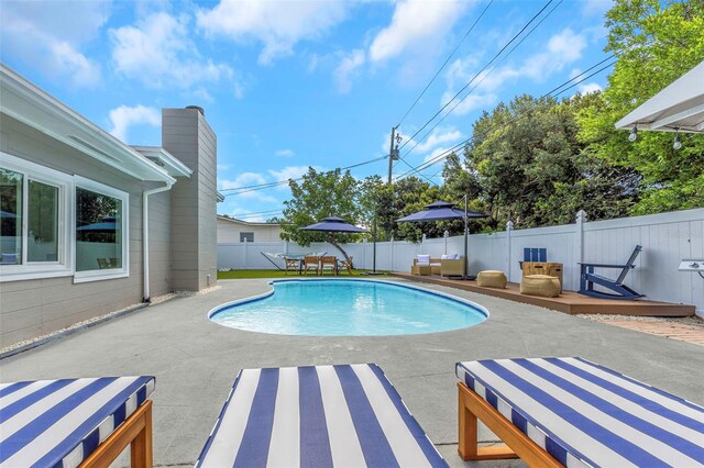 view of pool with a deck, a patio area, a fenced in pool, and a fenced backyard