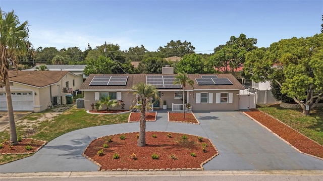 single story home with curved driveway, solar panels, fence, cooling unit, and a gate