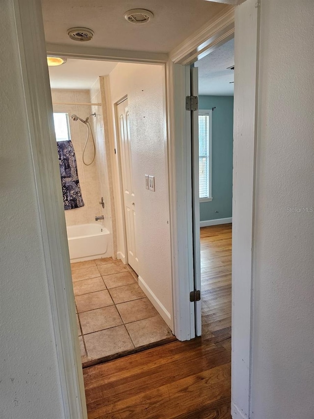 hall featuring baseboards and wood finished floors