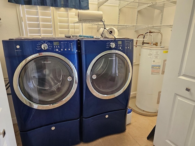 laundry room featuring tile patterned floors, washing machine and clothes dryer, water heater, and laundry area