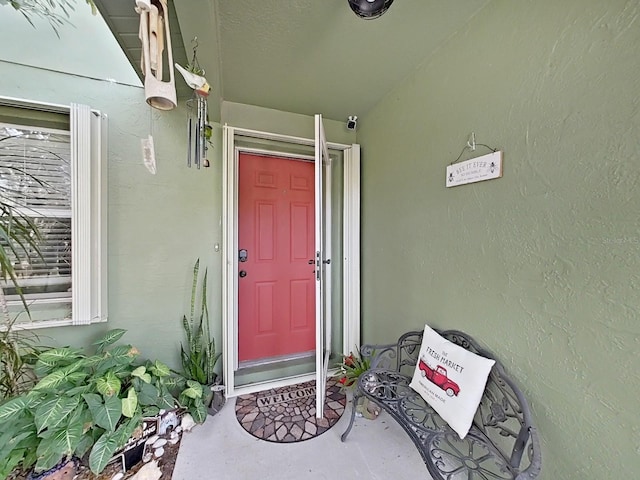 doorway to property featuring stucco siding