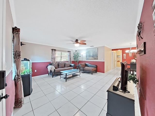 living area with crown molding, light tile patterned floors, ceiling fan with notable chandelier, and a textured ceiling