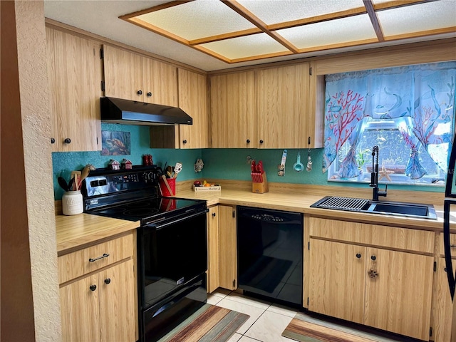 kitchen with black appliances, light countertops, under cabinet range hood, and a sink