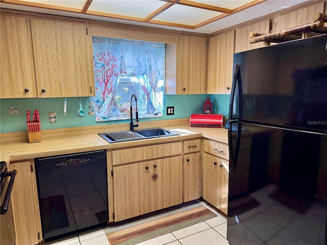 kitchen with black appliances, light brown cabinetry, a sink, light tile patterned flooring, and light countertops