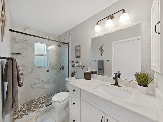 bathroom featuring a marble finish shower, toilet, a textured wall, marble finish floor, and vanity