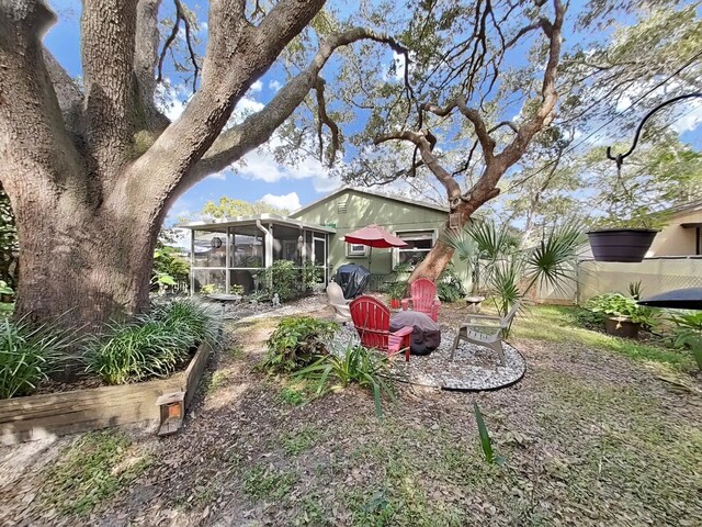 view of yard with fence and a sunroom