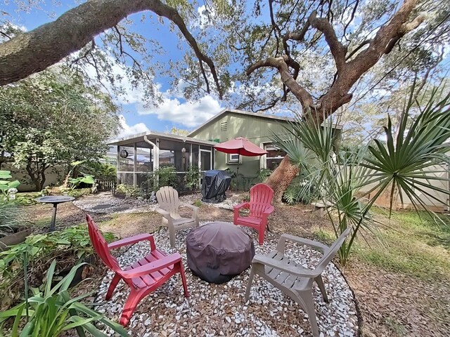 view of yard with an outdoor fire pit and a sunroom