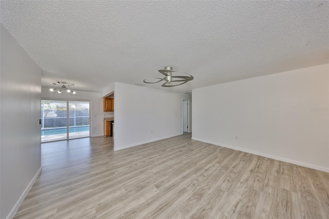 unfurnished living room featuring a textured ceiling, light wood-style floors, baseboards, and ceiling fan