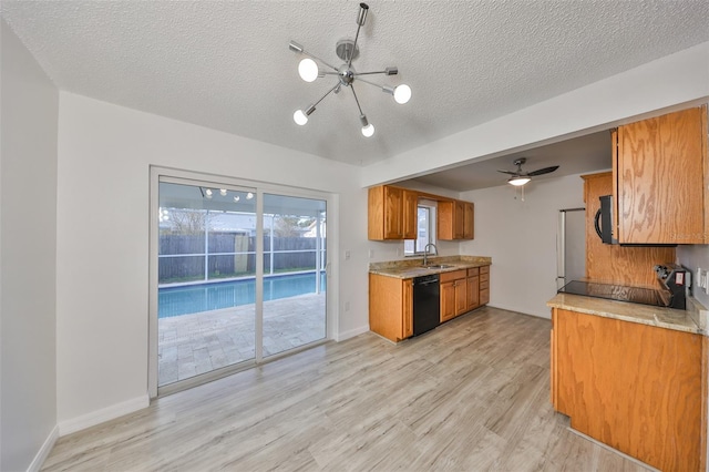 kitchen featuring a sink, brown cabinets, black appliances, and light countertops