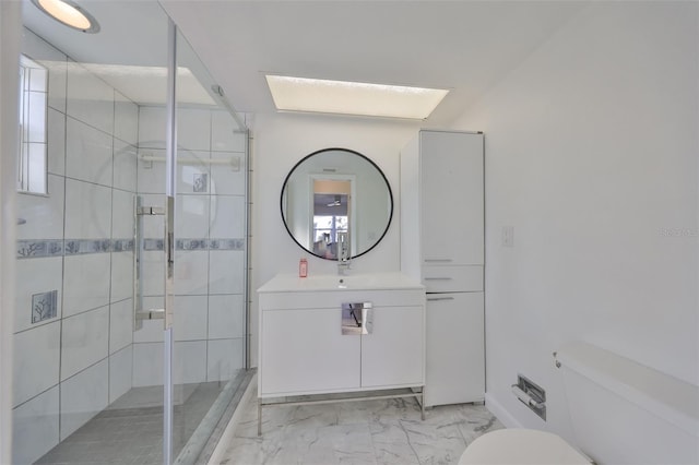 bathroom featuring vanity, toilet, marble finish floor, and a shower stall