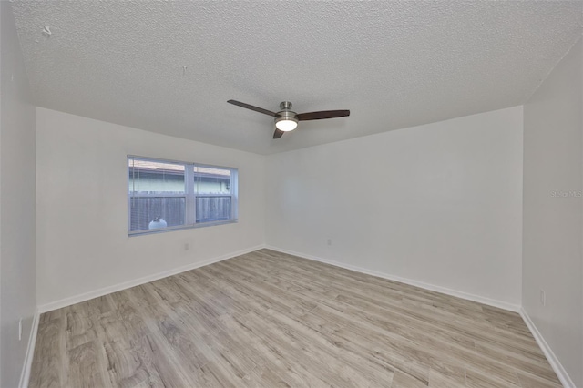 unfurnished room with a textured ceiling, light wood-style flooring, baseboards, and ceiling fan