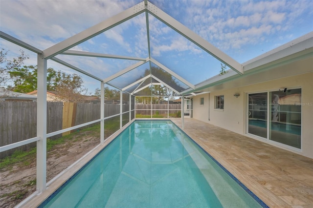 view of swimming pool with a patio area, glass enclosure, a fenced backyard, and a fenced in pool