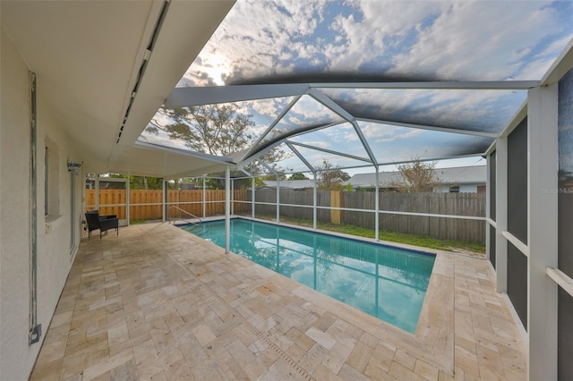 view of swimming pool with a lanai, a fenced in pool, a fenced backyard, and a patio area