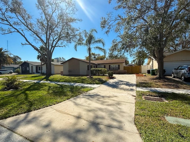 view of front facade with stucco siding, a front lawn, and fence