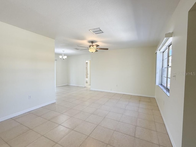 empty room with visible vents, baseboards, a textured ceiling, and ceiling fan with notable chandelier