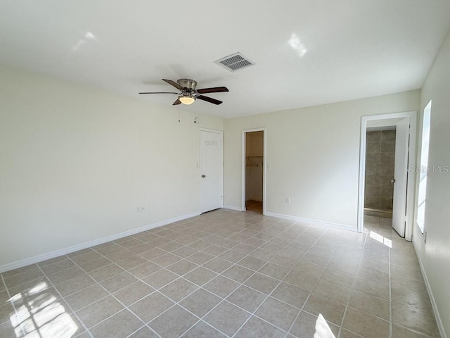 spare room with light tile patterned floors, visible vents, baseboards, and ceiling fan