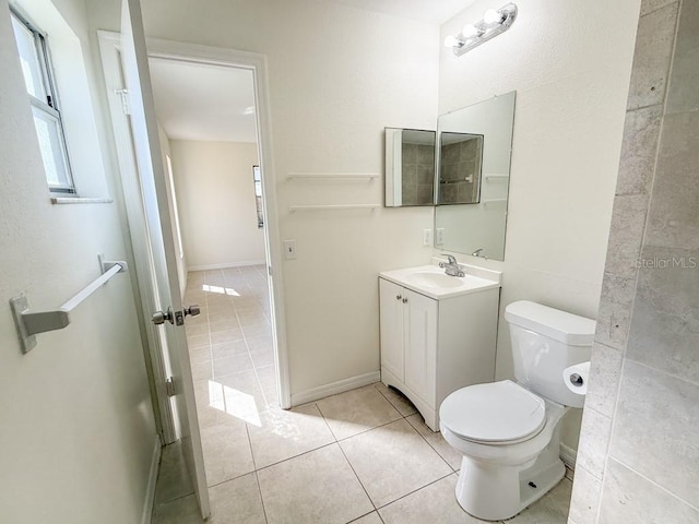 bathroom with baseboards, toilet, vanity, and tile patterned flooring