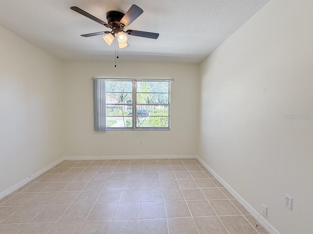 empty room featuring light tile patterned floors, baseboards, a textured ceiling, and ceiling fan