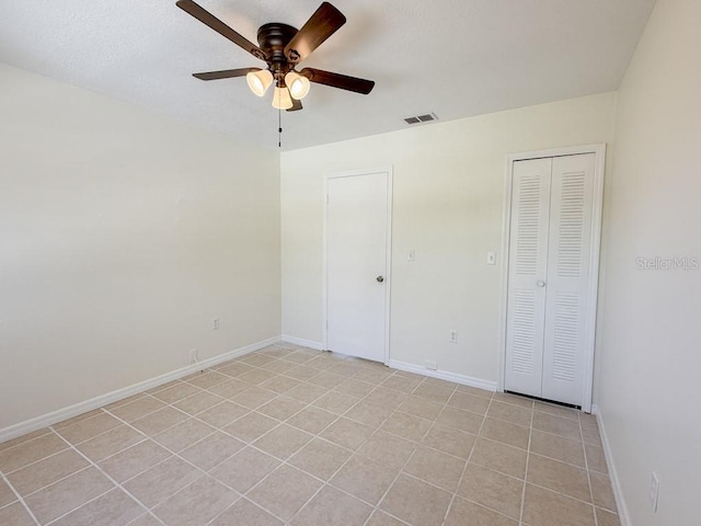 unfurnished bedroom with a closet, visible vents, ceiling fan, and baseboards