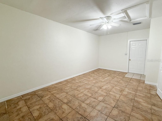 unfurnished room featuring a ceiling fan, baseboards, visible vents, attic access, and a textured ceiling