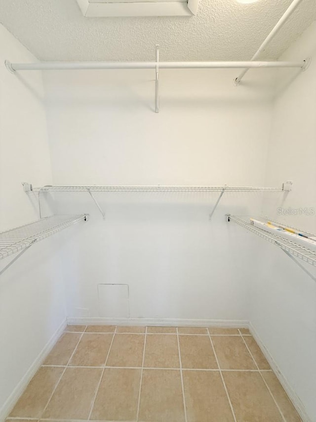 spacious closet featuring light tile patterned floors