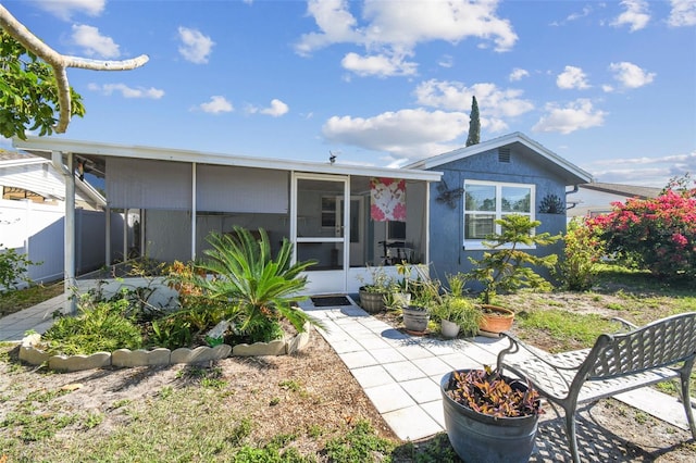 view of front of home featuring fence and a sunroom