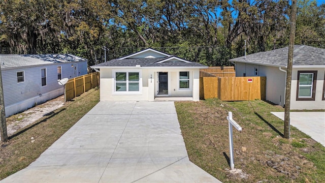 view of front facade featuring a front yard, fence, and stucco siding