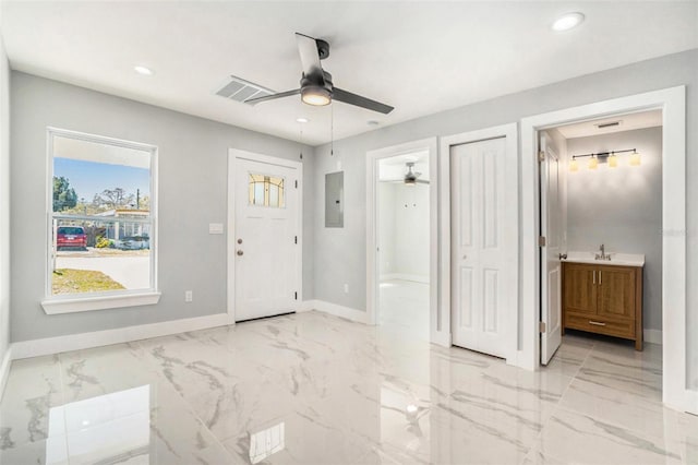 entryway featuring electric panel, recessed lighting, marble finish floor, and baseboards