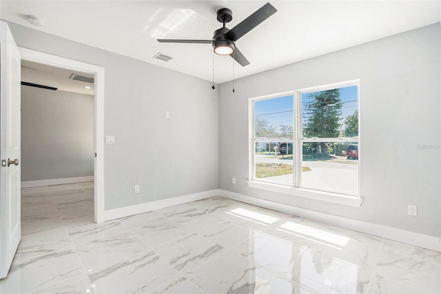 unfurnished room with visible vents, marble finish floor, baseboards, and ceiling fan